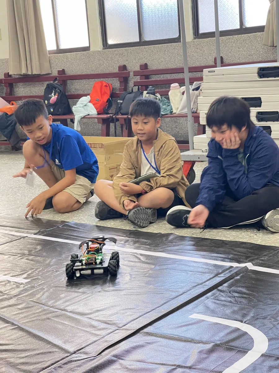 學生看著自走車在地墊上行駛